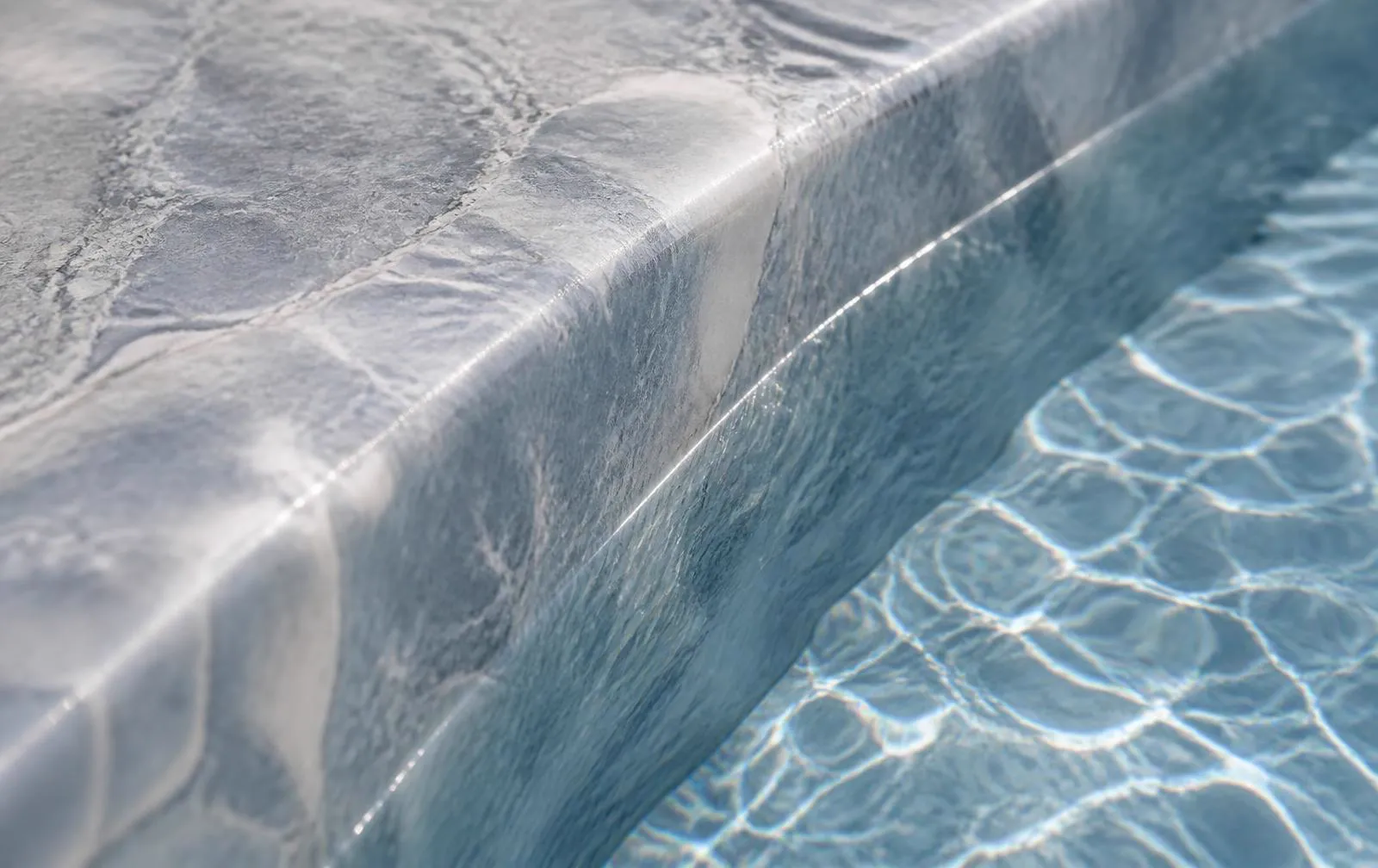 Macro detail of a marble-effect reinforced PVC pool membrane at the waterline
